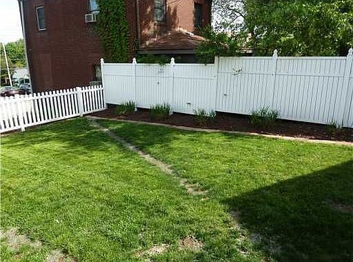 This lush, green yard is level and surrounded by a high-end privacy fence.