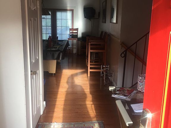 Foyer view/front door entrance into house. Wood flooring for half of first level