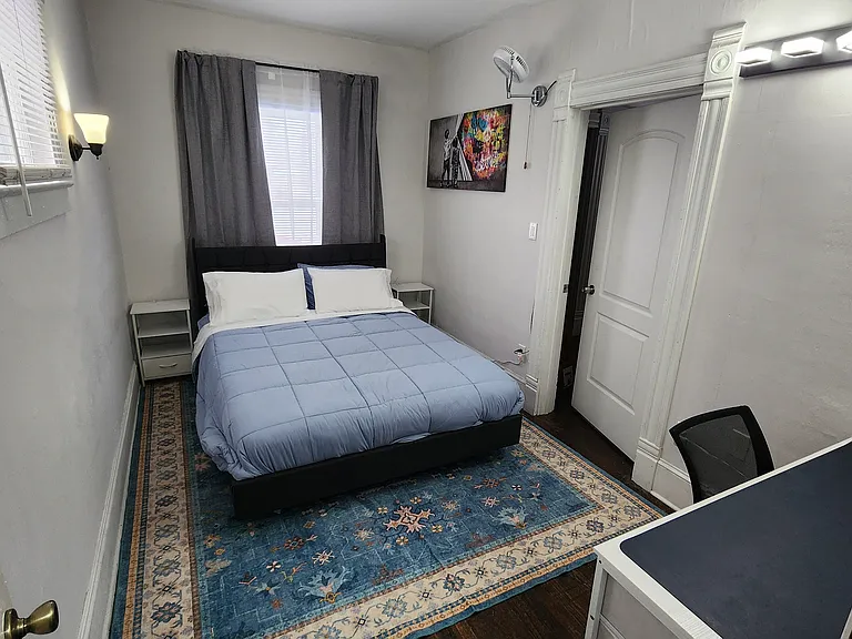 This is the first bedroom immediately to the right after walking in the front door. Entrance is in the room with the grey couch. Desk area. Queen bed. Large closet.