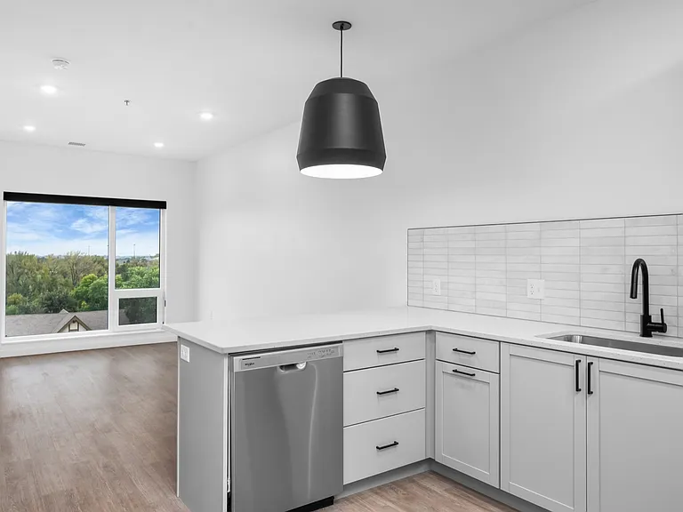 Modern kitchen with sleek stainless steel appliances, spacious white countertops, and a large window with scenic views. Modern kitchen with sleek stainless steel appliances, spacious white countertops, and a large window with scenic views.