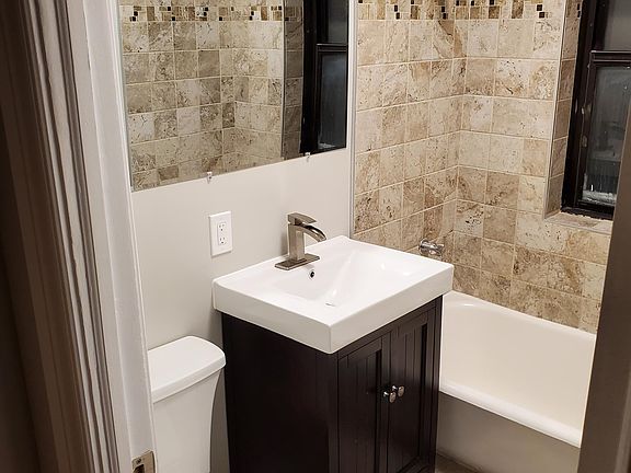7234-2N: Bathroom with ceramic wall tub surround and floors, full size mirror
