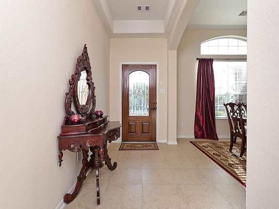Large entry with high ceilings and tile floor open to the dining room.