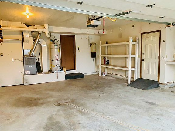 Nice-sized garage with storage space and workbench.