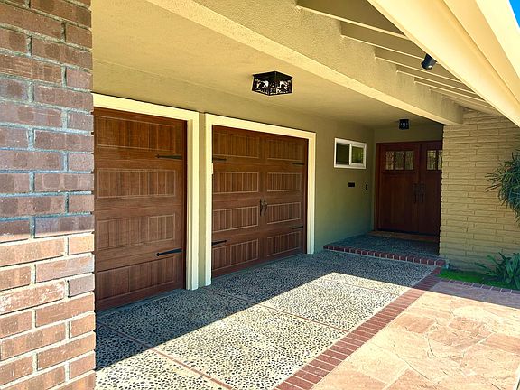 View of Garage Doors and Front Entry. New Interior and Exterior Doors throughout House.
