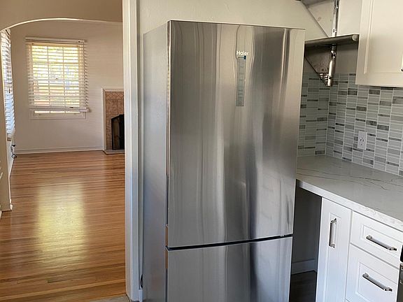 New refrigerator with bottom door freezer. New cabinets include pull-out spice cabinet and extra stainless steel shelves for less frequently used items and appliances.