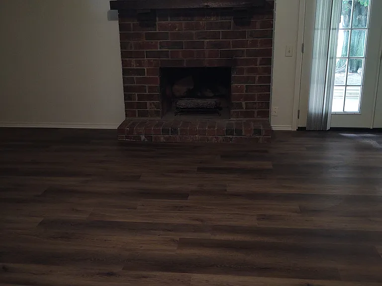 Spacious Living room with fire place and French doors to covered back patio.
