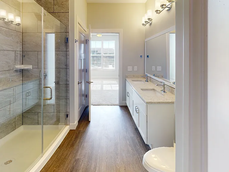 Two sinks mean no more waiting! The Redbud's spacious bathroom with a walk-in shower and dual vanities makes everyday routines simple and relaxed. Two sinks mean no more waiting! The Redbud's spacious bathroom with a walk-in shower and dual vanities makes