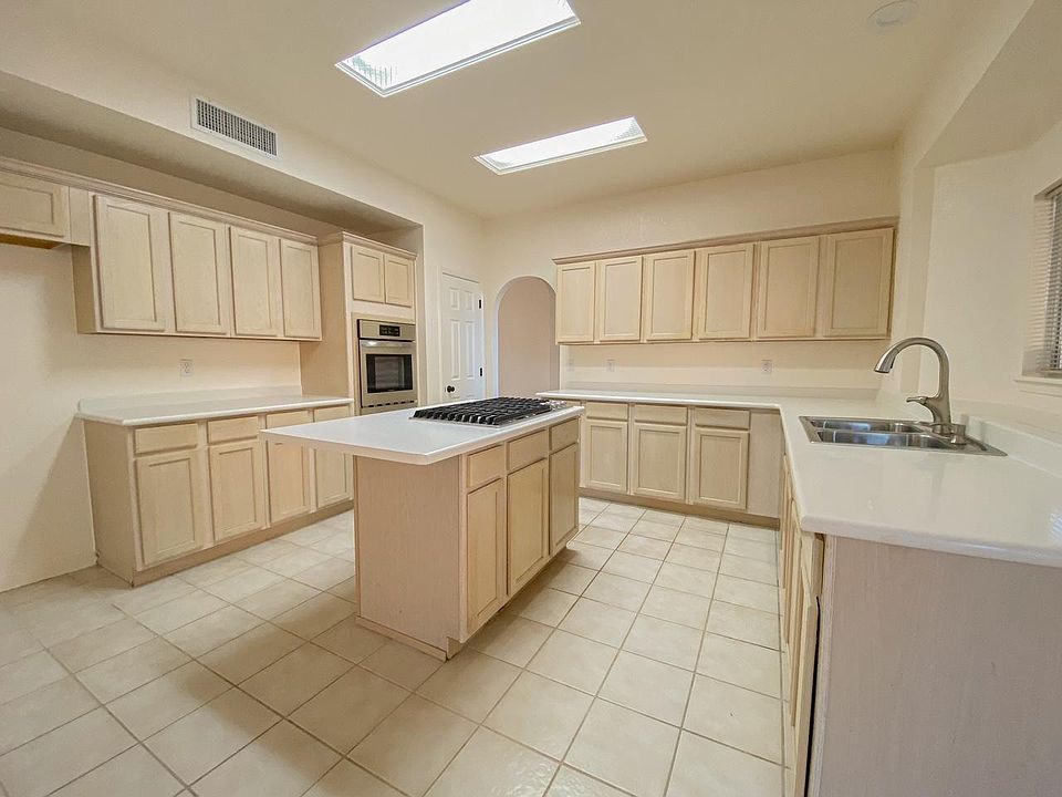 A spacious island kitchen with new stainless-steel gas stovetop and electric wall oven. Lots of kitchen cabinet storage and a new kitchen faucet.