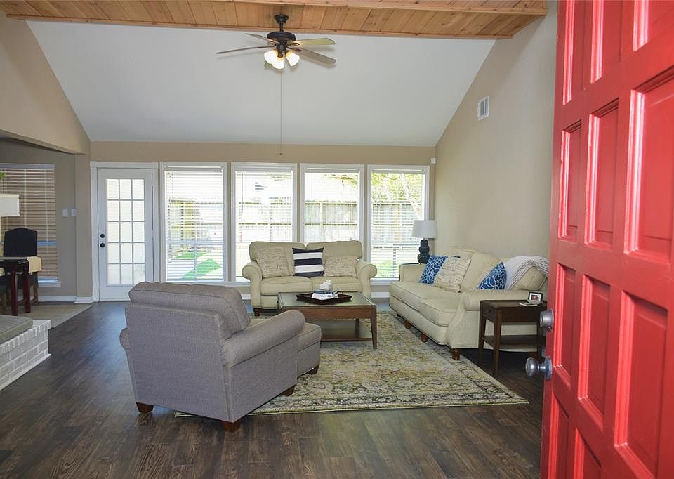 Come on in to this inviting living room with cedar beam ceiling, laminate wood floor, wall of windows, stone fire place.