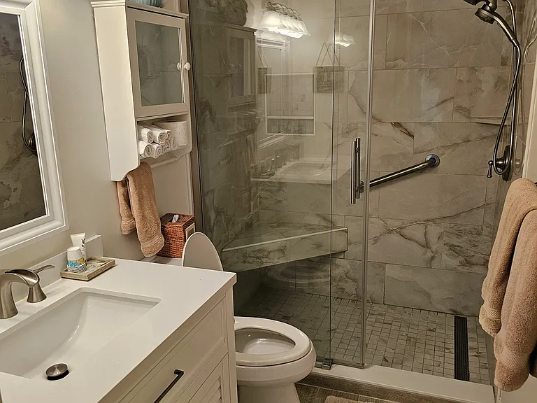 The guest bathroom has a walk-in shower with a seat.
