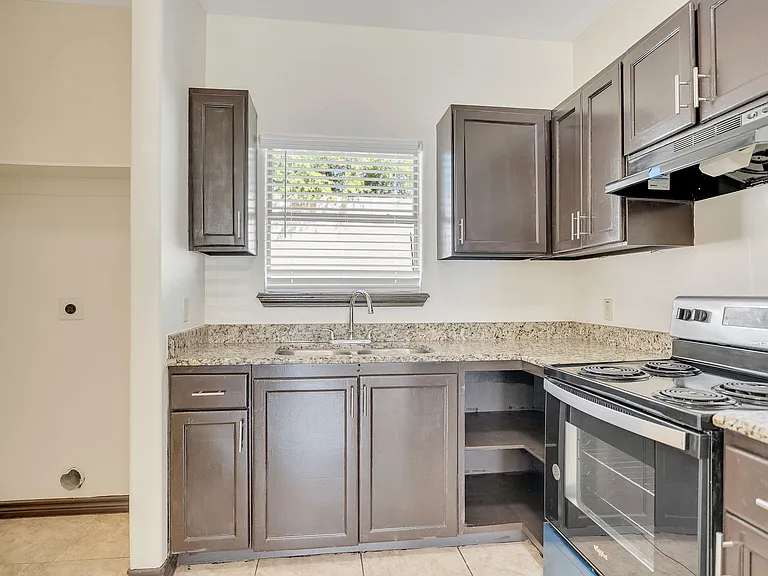Contemporary kitchen showcasing stainless steel appliances and granite countertops at La Joya Apartments in Laredo, Texas
