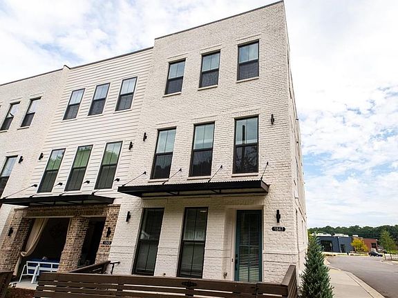 STATELY END UNIT OF WHITE-PAINTED BRICK, FENCED GATE ENTRY, AND BEAUTIFUL LARGE WINDOWS PROVIDING LI