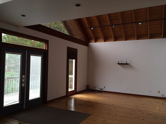 living room area with vaulted ceiling opens to deck