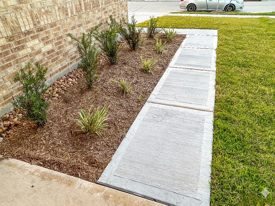 Well-maintained front walkway featuring fresh landscaping, clean concrete paths, and lush green lawn.