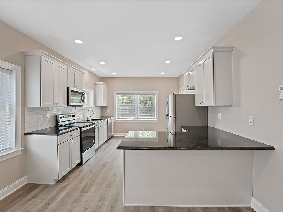 New kitchen with stainless appliances, granite countertops, and tiled backsplash