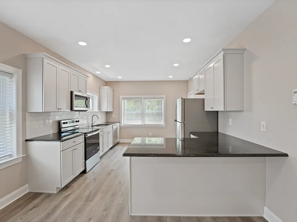 New kitchen with stainless appliances, granite countertops, and tiled backsplash