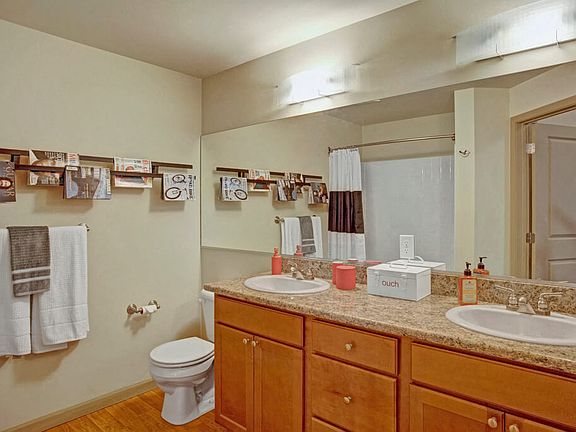 A spacious bathroom with double sinks, a large mirror, and lots of cabinet storage