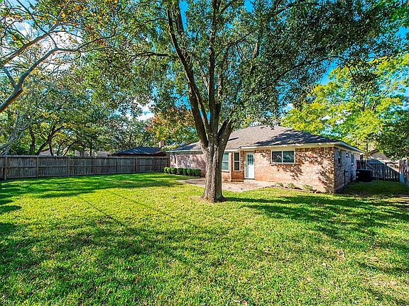 Expansive backyard with beautiful shade tree.