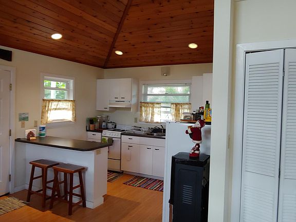 Kitchen with stove, refrigerator and distilled water dispenser. Breakfast counter.