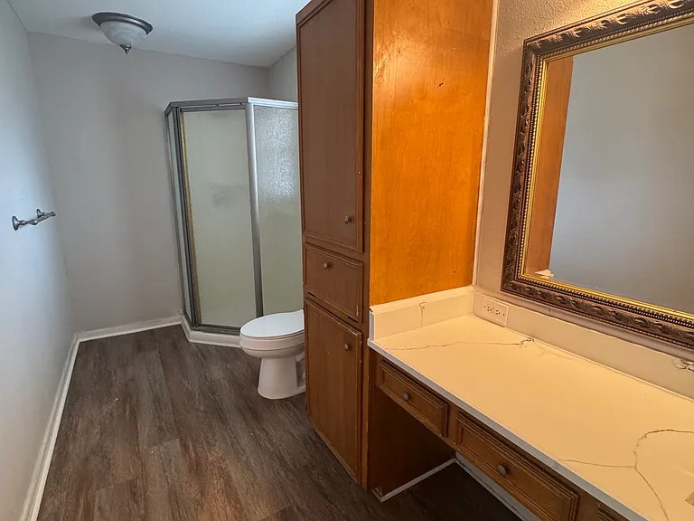 This bathroom has a new quartz counter and new toilet.