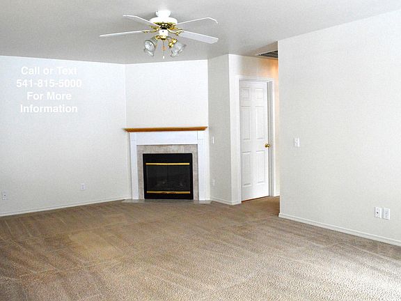Gas fireplace in living room with ceiling fan