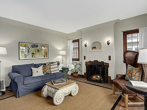 Gracious west facing living room with hardwood floors, coved ceiling, classic tile fireplace, leaded glass windows, and a territorial view.