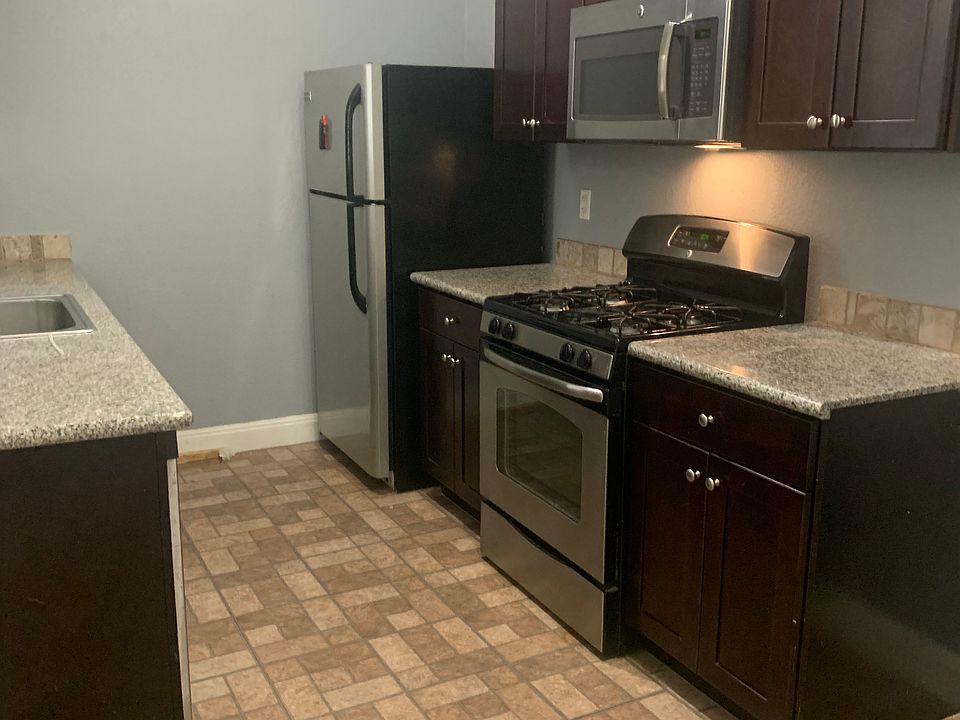 Kitchen with granite counter, gas appliances, microwave, and dishwasher.