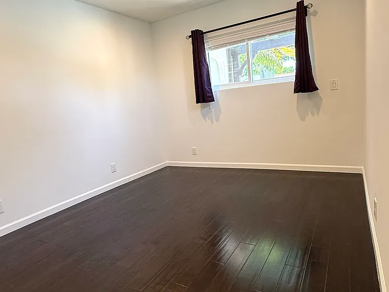 Primary bedroom featuring two windows, dimmable recessed LED lighting, a ceiling fan, a walk-in closet, and an en-suite bathroom.