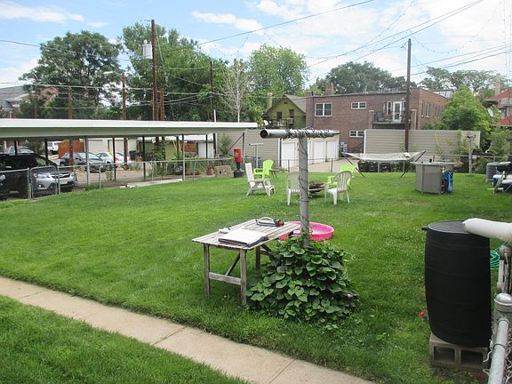 Backyard and covered parking in background.