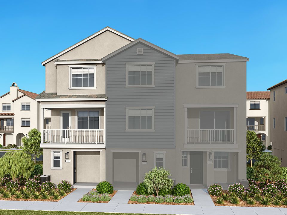 A multi-story residential building with a gray exterior, surrounded by landscaped greenery and set a