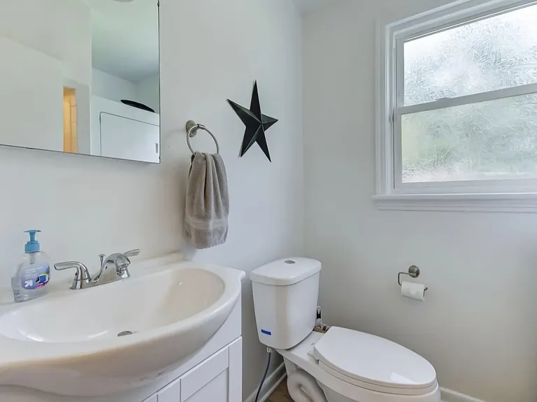 Guest toilet across from an included stackable new washer/dryer unit