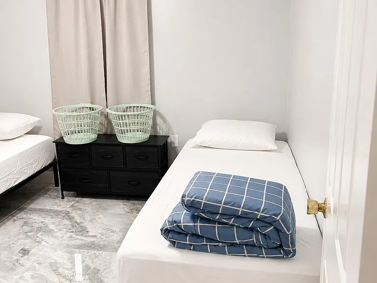 Furnished bedroom with twin beds, a multi-drawer dresser, and tile flooringset up for convenient shared living.