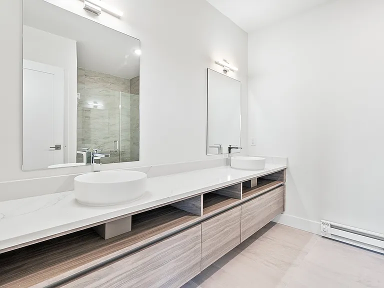 The primary bathrooms showcase elegant ceramic tile flooring, dual vanities, classic subway tile accents, and contemporary finishes_combining style and functionality for a luxurious experience.