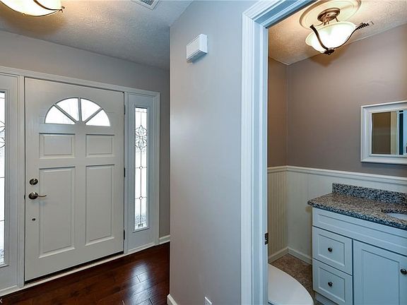 Pictured: Foyer entry with 1st floor powder room. 1st floor powder room features new flooring, new granite countertops, a new vanity, hardware, light fixtures and more!