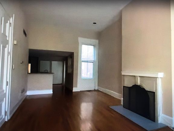 Living room looking into kitchen from front windows. Dining area to the right.