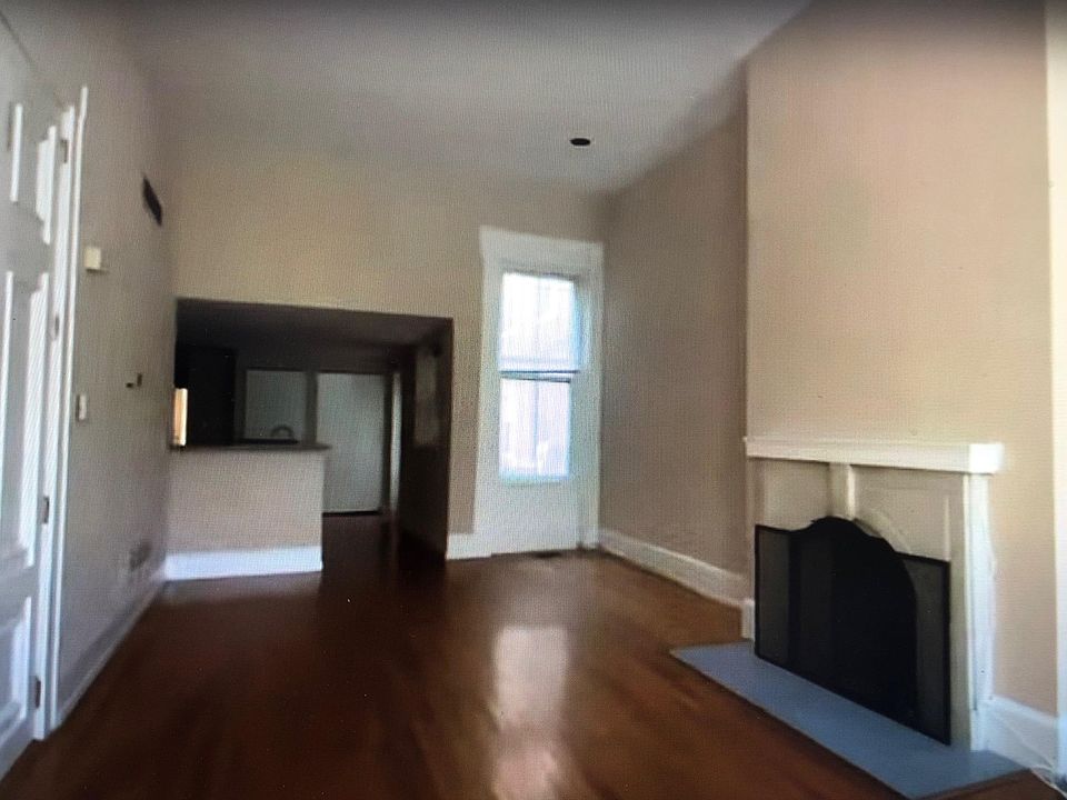 Living room looking into kitchen from front windows. Dining area to the right.