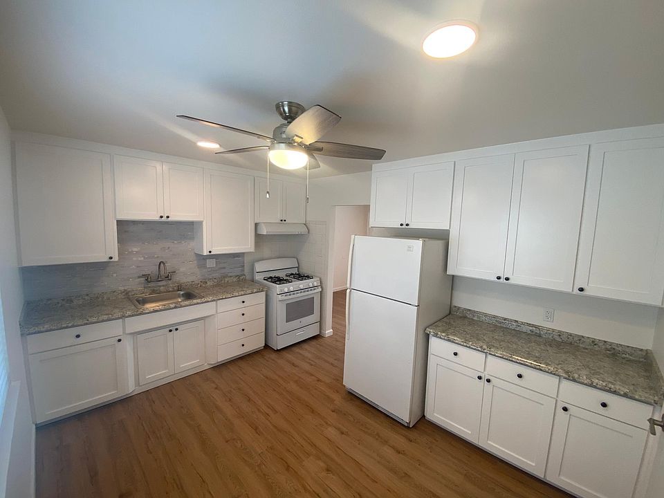 Kitchen includes gas stove, hood fan, refrigerator. New fan and recessed lighting.