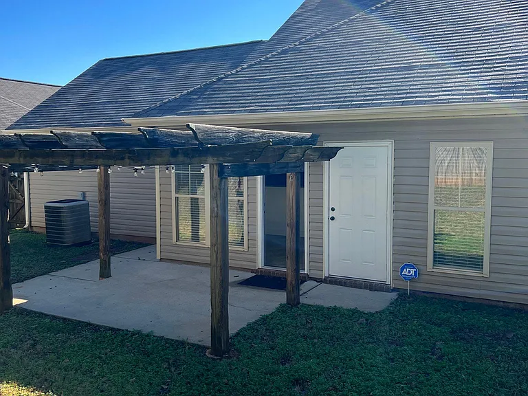 Pergola covered patio off kitchen and outside storage closet.