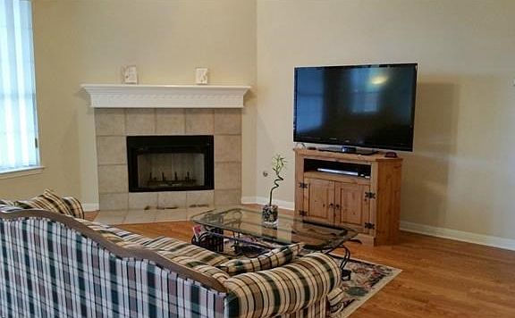Living room with gas or wood burning fireplace; crown molding and opens to kitchen and breakfast area