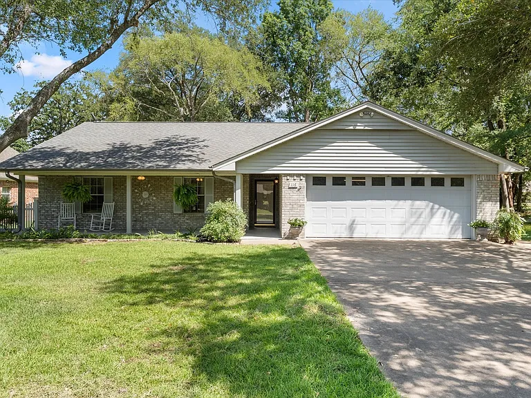 Brick and siding exterior with a covered front porch featuring white columns and a gray shingle roof