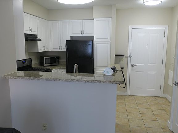 Standing in LR looking at breakfast bar and entryway