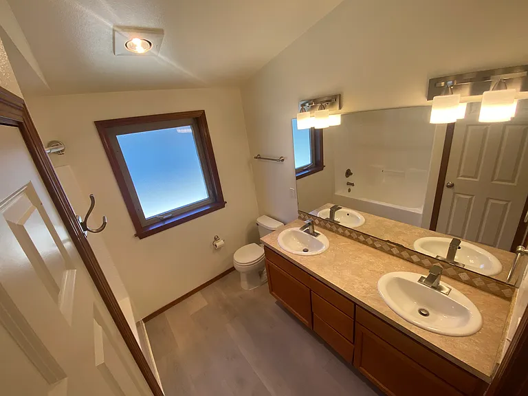 3rd Floor _ Primary bathroom with a dual-sink vanity, updated flooring, a large linen closet, and a built-in heat lamp.