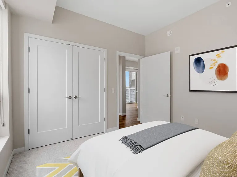 Bright bedroom with French doors to spacious walk-in closet at The Hallon Luxury Apartments in Hopkins MN