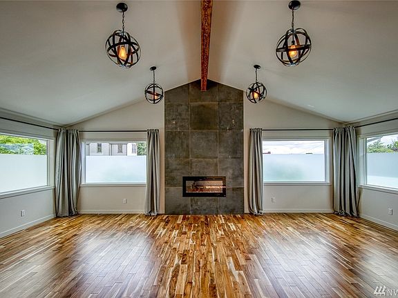 The heart of the property is this expansive room with newly vaulted beamed ceiling, four picture windows which capture mountain views, and a stunning electric fireplace wall.  