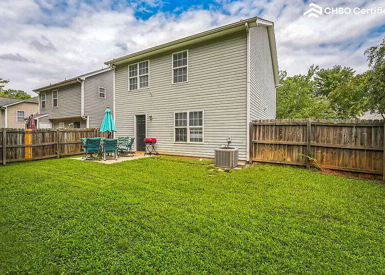 Fenced yard with BBQ grill.