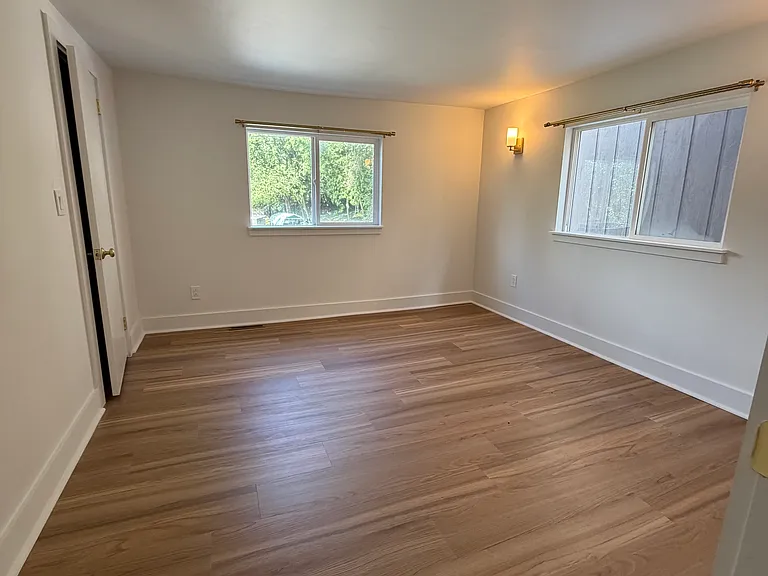 Bedroom 1 with 2 large windows, a closet with shelf and clothes rod and curtain rods for windows pre installed.