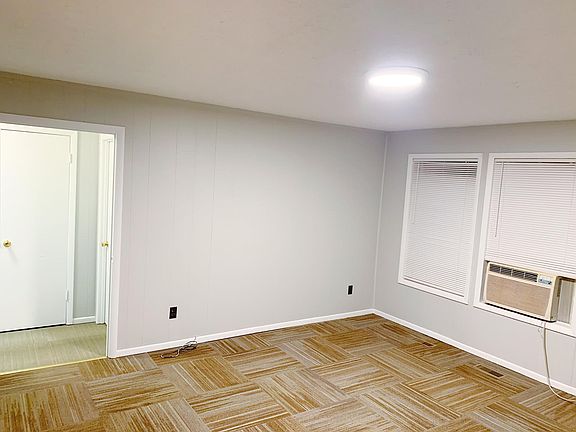 Freshly painted living room featuring new light fixture and blinds.