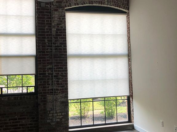 Living space with original brick walls and industrial sized windows