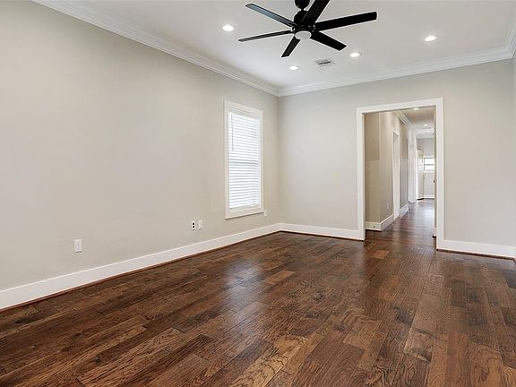 Living room with hickory wood floors, ceiling fan, and recessed lighting.