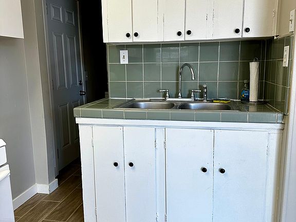 kitchen sink with opening to laundry area.